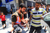 A man carries the body of a Palestinian child killed in an Israeli strike, in Gaza City