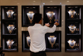 FILE PHOTO: An employee arranges gold necklaces at a jewellery store in Mumba