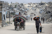 Palestinians make their way with belongings as they flee their homes