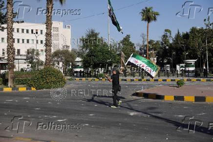 People gather near a damaged site, in Damascus
