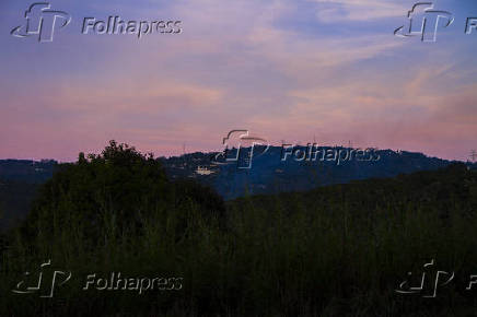 Céu azul, com nuvens de nuances alaranjadas, no penúltimo dia do outono