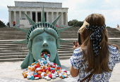 Pills spill out of the mouth a Lady Liberty installation at the Lincoln Memorial in Washington