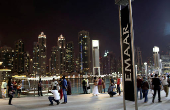 FILE PHOTO: People have their pictures taken near an Emaar sign outside the Dubai Mall