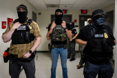 A migrant is detained by federal immigration officers at U.S. immigration court