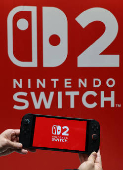 A staff poses with Nintendo Switch 2 at a media event in Tokyo