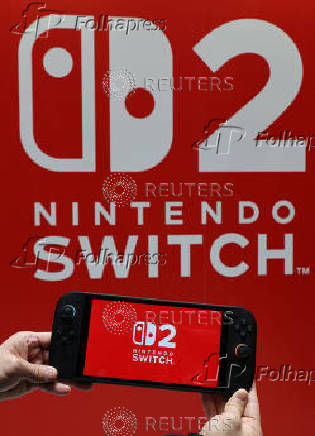 A staff poses with Nintendo Switch 2 at a media event in Tokyo