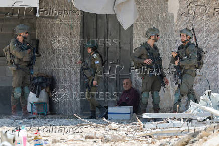 Palestinians carry their belongings after Israel's decision to demolish their homes in Nur Shams camp