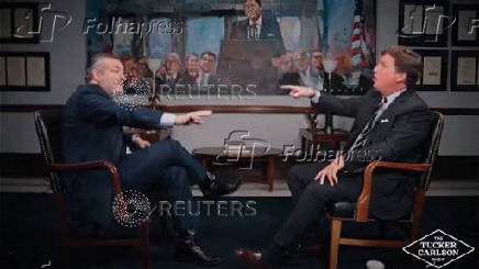 Conservative podcast host and commentator Tucker Carlson engages in an exchange with U.S. Senator Ted Cruz