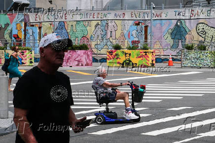 People pass in front of Frank Ape's 
