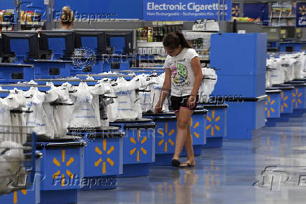 FILE PHOTO: A girl walks along the checkouts at the Wal-Mart Supercenter in Springdale