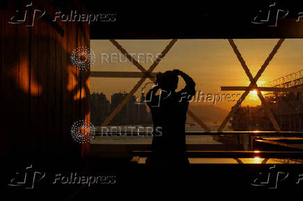 A shop worker tapes a glass window in preparation for Typhoon Ragasa at a store in Hong Kong