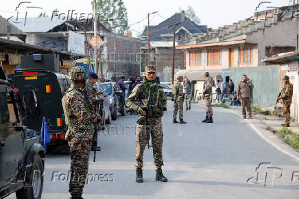Indian security force personnel stand guard near the site of a fighter jet crash in Wuyan