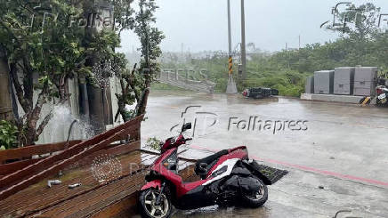 Bikes lie on a road during a storm, in Green Island