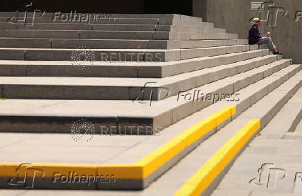 A Health and Human Services worker sits on the steps of the agency headuarters in Washington