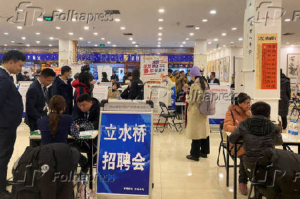 FILE PHOTO: People attend a job fair in Beijing