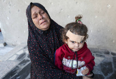 Palestinians inspect the damage at the site of an Israeli strike on a house, in Jabalia