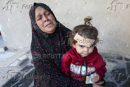Palestinians inspect the damage at the site of an Israeli strike on a house, in Jabalia