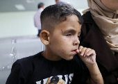 A Palestinian boy in need of medical treatment arrives at King Hussein Bridge crossing, in South Shuna