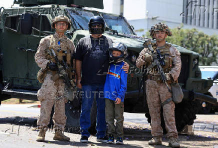 U.S. Marines stand at a checkpoint as they guard a federal building, in Los Angeles