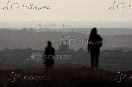Israeli soldiers stand guard during the rally organized by settlers groups to promote Israel's resettling in Gaza