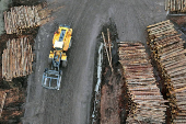 A drone view of a loader moving past cut logs outside the sawmill facility at Gorman Bros. Lumber Ltd. in West Kelowna
