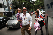 Migrants gather outside the Venezuelan embasssy waiting for a flight back to their country