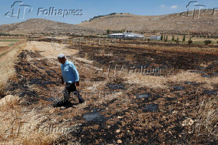 A Palestinian man walks at his farm, after an Israeli settlers attack in Al Mughayyir near Ramallah