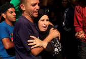 People react as Palestinian casualties, who were waiting to receive aid, are brought into Nasser hospital following an Israeli strike, in Khan Younis