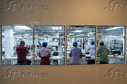 FILE PHOTO: Employees sew garments inside a garment factory in Katunayake on the outskirts of Colombo