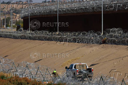 Members of the U.S. military replace concertina wire at on the U.S.-Mexico border, as seen from Ciudad Juarez