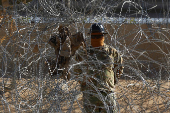 Members of the U.S. military replace concertina wire at on the U.S.-Mexico border, as seen from Ciudad Juarez