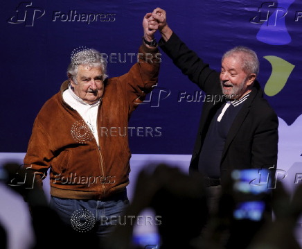 Former Presidents Mujica of Uruguay and Lula of Brazil greet the public during the second day of the VII Latin American Council of Social Sciences in Medellin