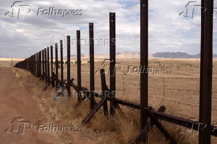 A vehicle barrier cuts through the San Rafael Valley