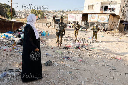 Israeli soldiers prevent Palestinians who came to visit the graves of their relatives from reaching the cemetery in Jenin camp