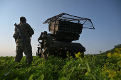 Ukrainian servicemen prepare a multiple rocket launcher before firing towards Russian troops on a front line in Zaporizhzhia region