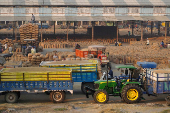 FILE PHOTO: Tractor trolleys loaded with rice crops wait to be unloaded in a grain market in Karnal
