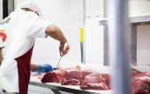 Açougueiro manipula peças de carnes em estabelecimento comercial especializado