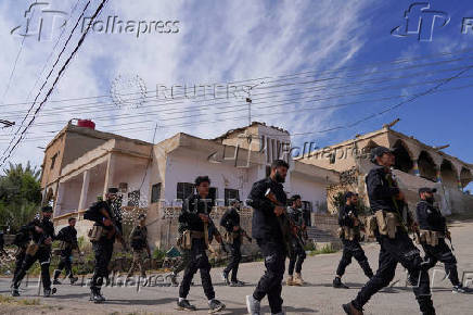 Syrian security forces deployed in the village of Al-Soura al-Kubra