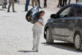 Palestinians carry their belongings after Israel's decision to demolish their homes in Nur Shams camp