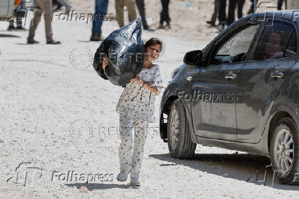 Palestinians carry their belongings after Israel's decision to demolish their homes in Nur Shams camp
