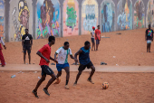 Men play soccer near a graffiti mural in Yoff, neighborhood of Dakar