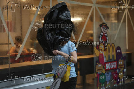 A woman braves strong winds as Typhoon Wipha approaches, in Hong Kong