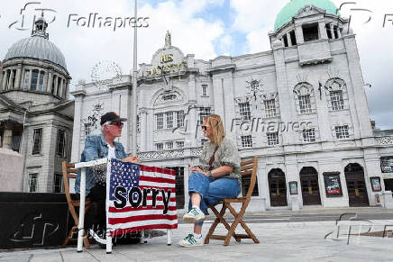 U.S. artist Joseph DeLappe sits at his 'United States Apologies Desk' ('USAD') during U.S. President Donald Trump's visit to Scotland, in Aberdeen