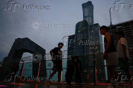 People walk on a terrace of a shopping mall at the central business district (CBD), in Beijing
