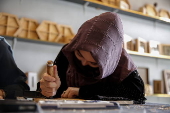 Afghan girl teach Nuristani wood carving skills at a workshop in Kabul