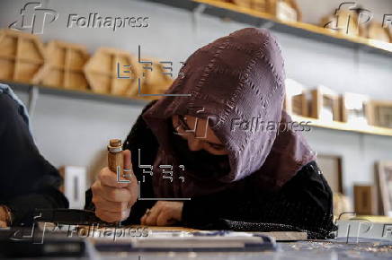 Afghan girl teach Nuristani wood carving skills at a workshop in Kabul