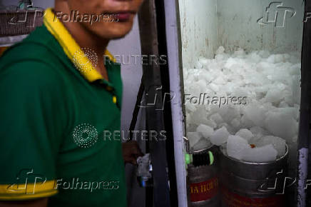 A worker opens a room containing kegs of 