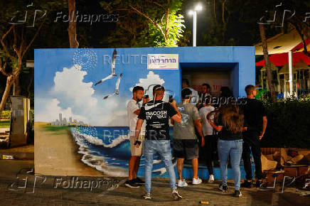 People take cover in a bomb shelter as a siren is heard, in Ashkelon