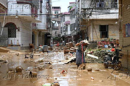 Resident cleans up a street after heavy rainfall led to flooding in Zhaoqing