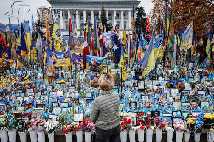 Woman appears in front of the makeshift memorial to fallen Ukrainian defenders at Independence Square in Kyiv